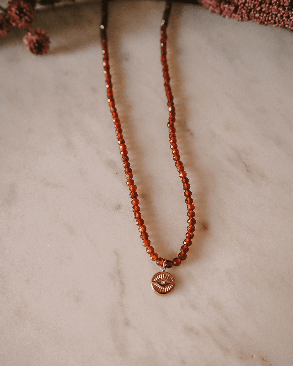 Naszyjnik z ognistych granatów z okiem